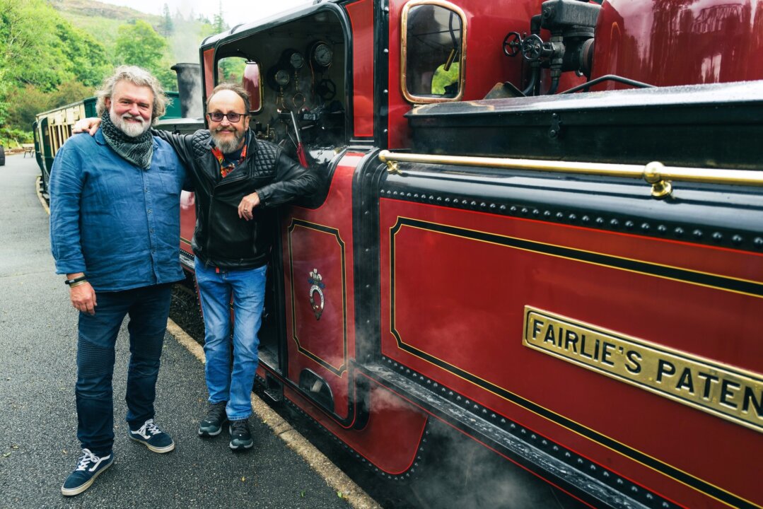 Si KIng and Dave Myers at the standing by a red train at the Ffestiniog Railway in North Wales